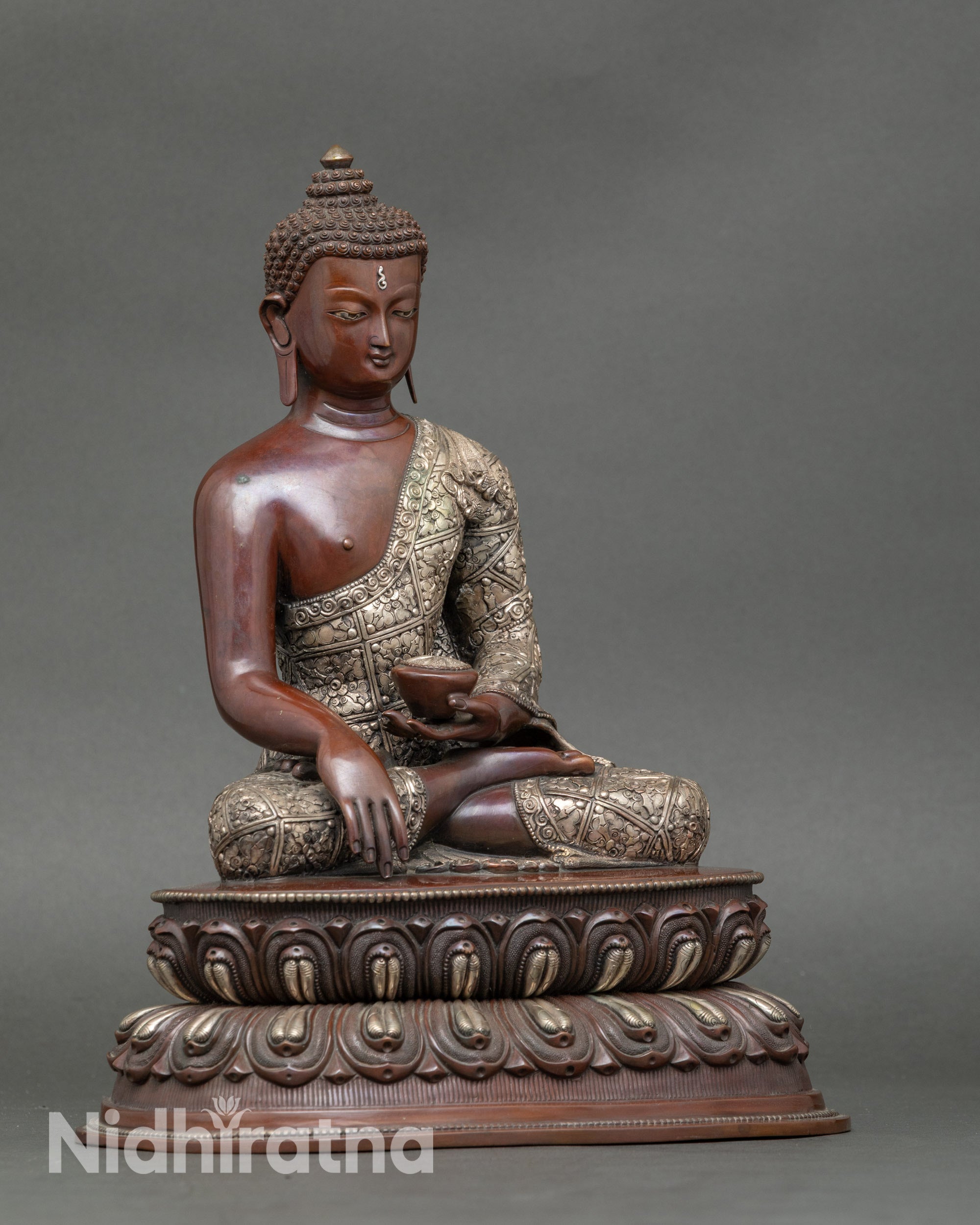 Side view of Siddhartha Gautama Buddha statue seated on lotus with monk’s bowl
