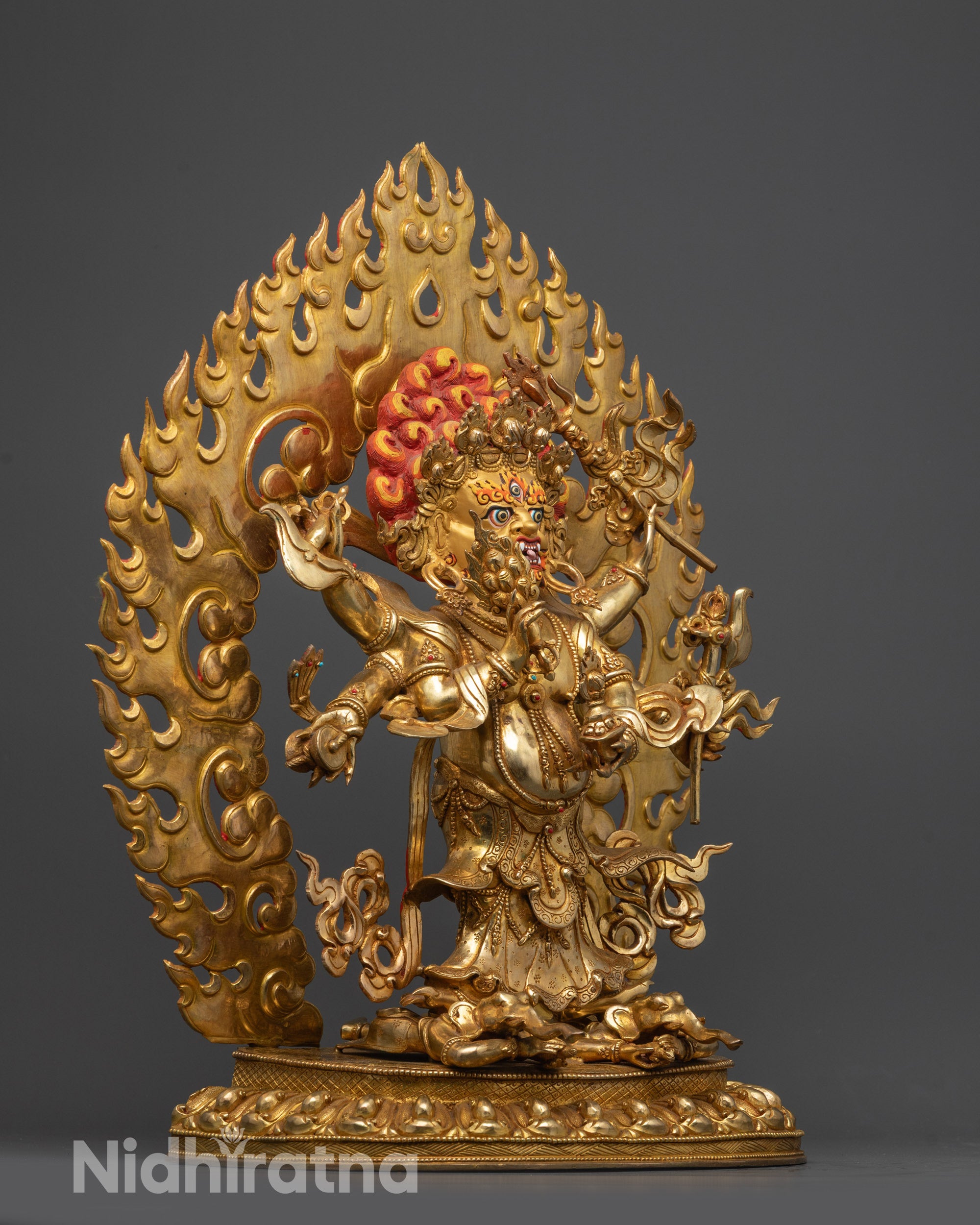 Side view of Six-Armed White Mahakala holding trident, hook, skull cup, knife, and damahru