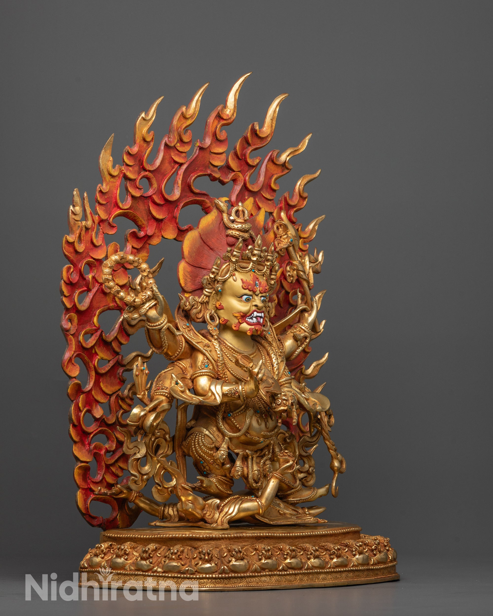 Side view of Six Armed Mahakala statue showing intricate hand-carved details