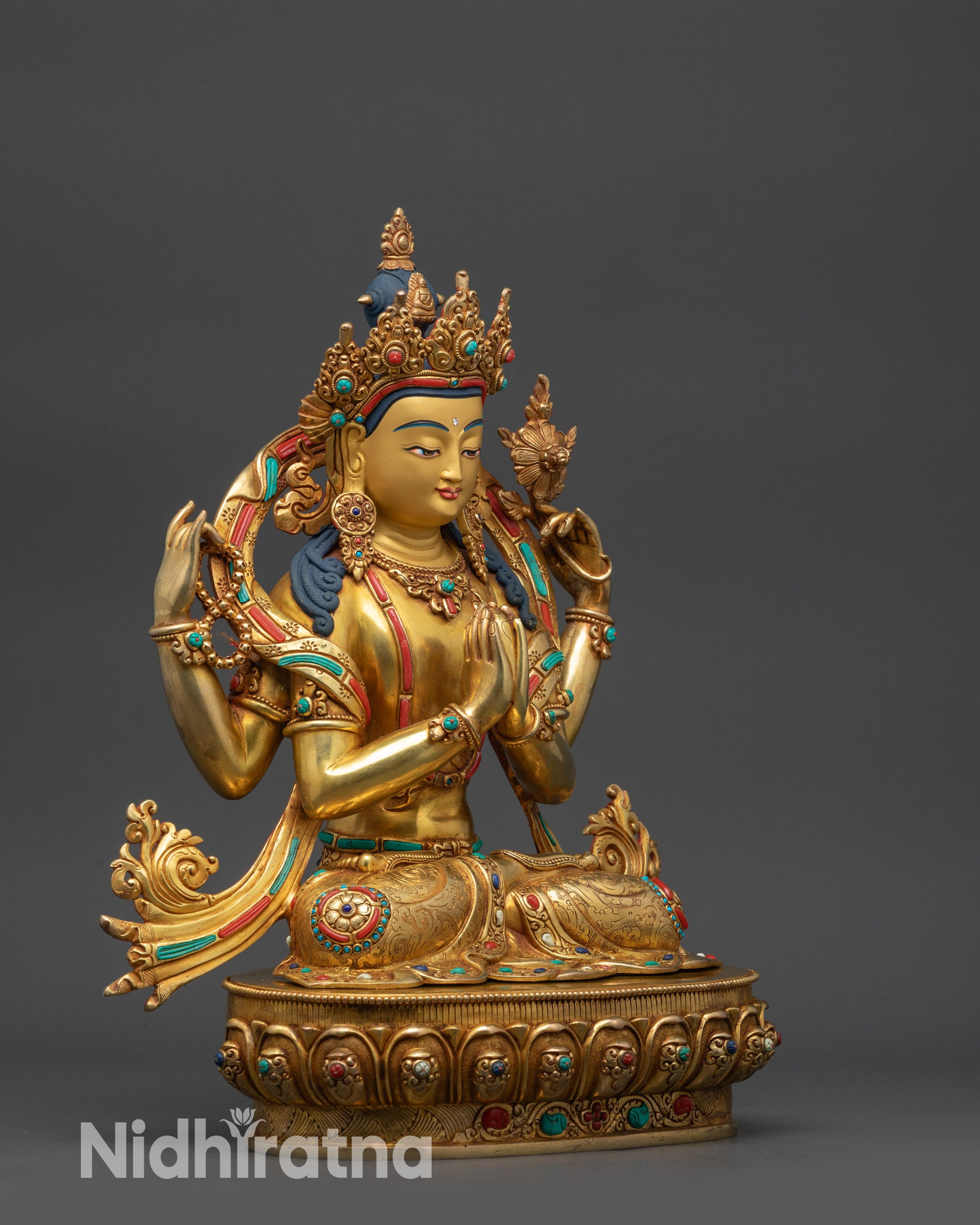 Side view of Tibetan Chenrezig Buddha with swirling robes and sacred motifs visible