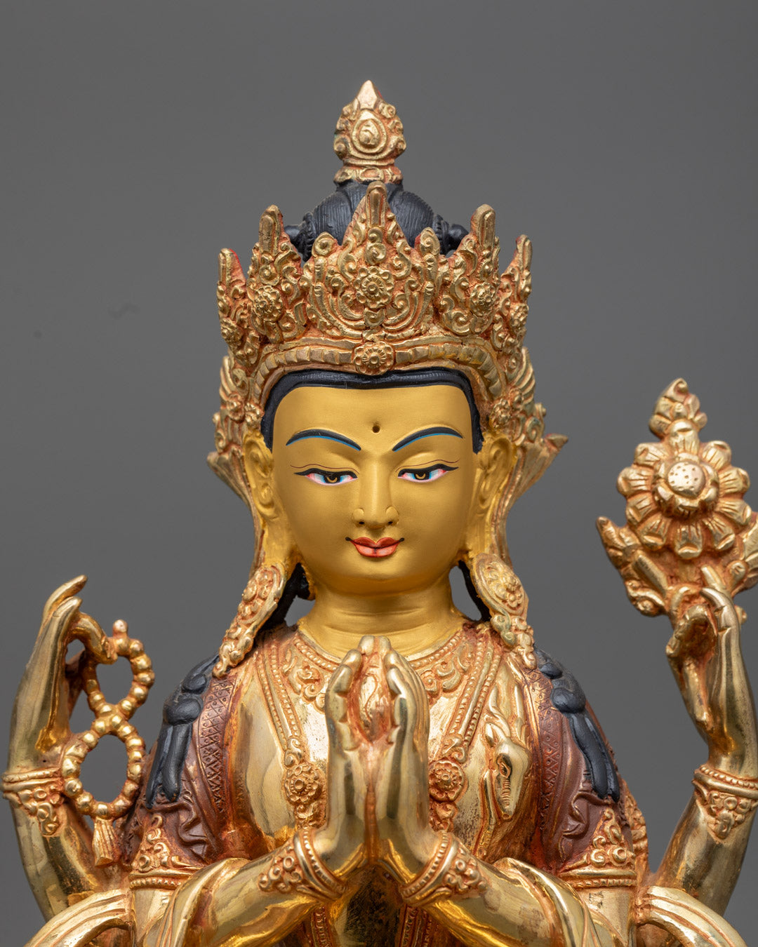 Tibetan Chenrezig Sculpture highlighting detailed hand-carving, acrylic colors, and multiple arms representing the Four Immeasurables.