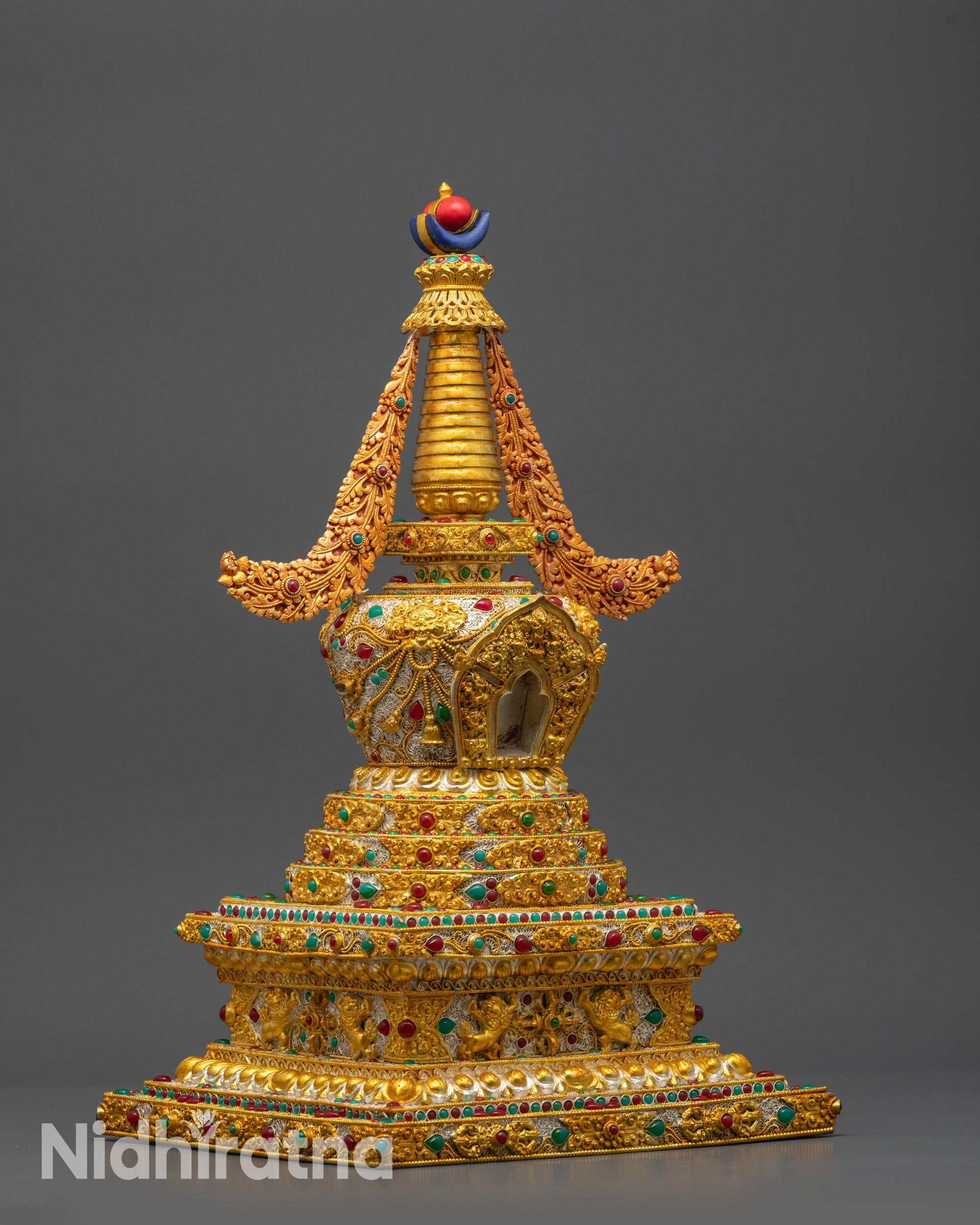 Side view of Tibetan Golden Stupa showcasing intricate silver filigree and patterns
