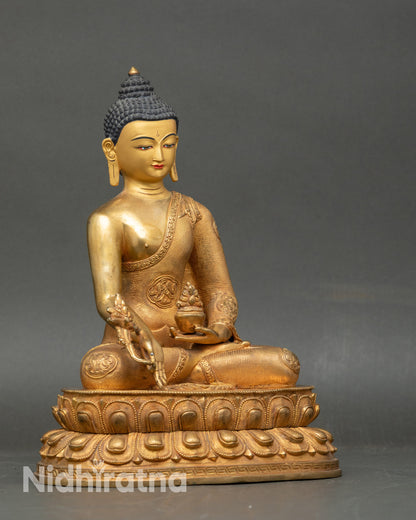 Side view of Tibetan Medicine Buddha statue in floral monk robes, gold fire-gilded copper art