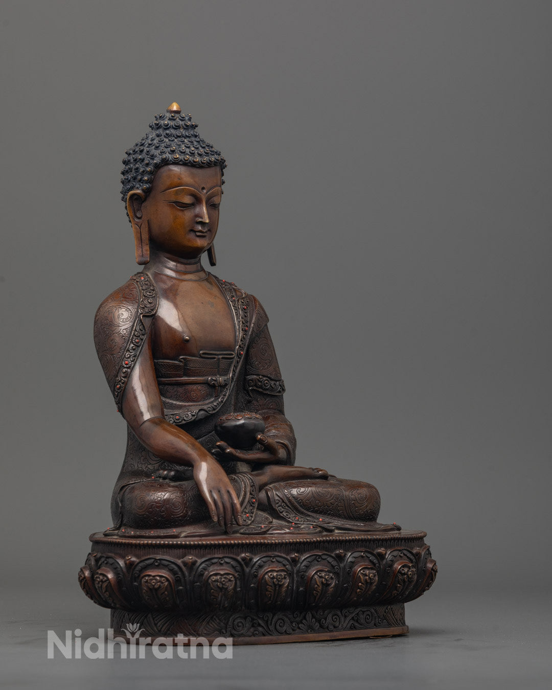 Side view of Traditional Nepalese handcrafted Shakyamuni Buddha holding monk’s bowl