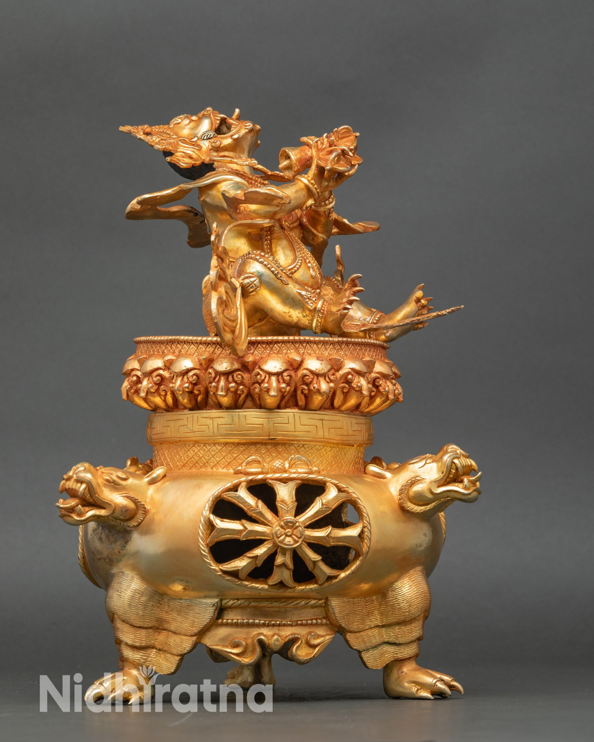 Side view of Vajradhaka statue seated on hollow incense burner base for fire rituals