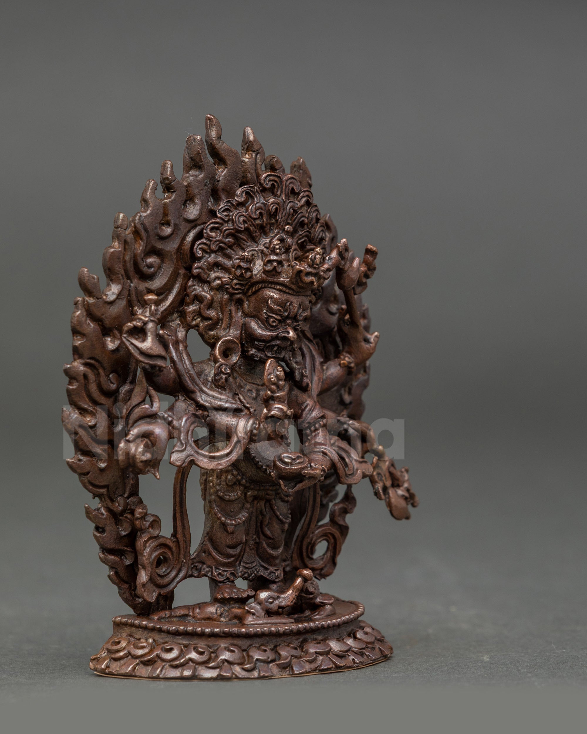 Side view of White Mahakala Statue highlighting trident, skull cup, and lotus seat