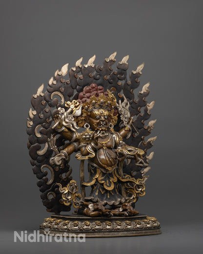 Side view of White Mahakala statue crushing two spirits with flowing robes and jewelry