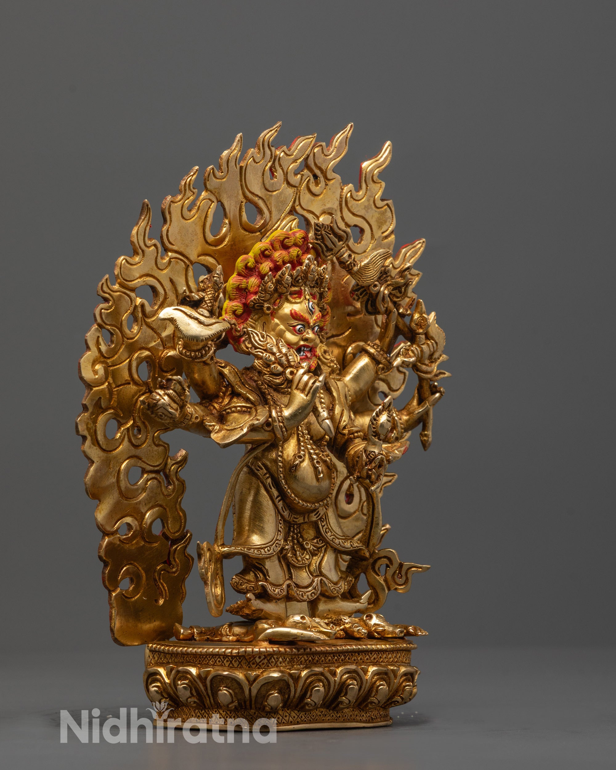 Side view of White Six-Armed Mahakala statue featuring six arms holding sacred objects