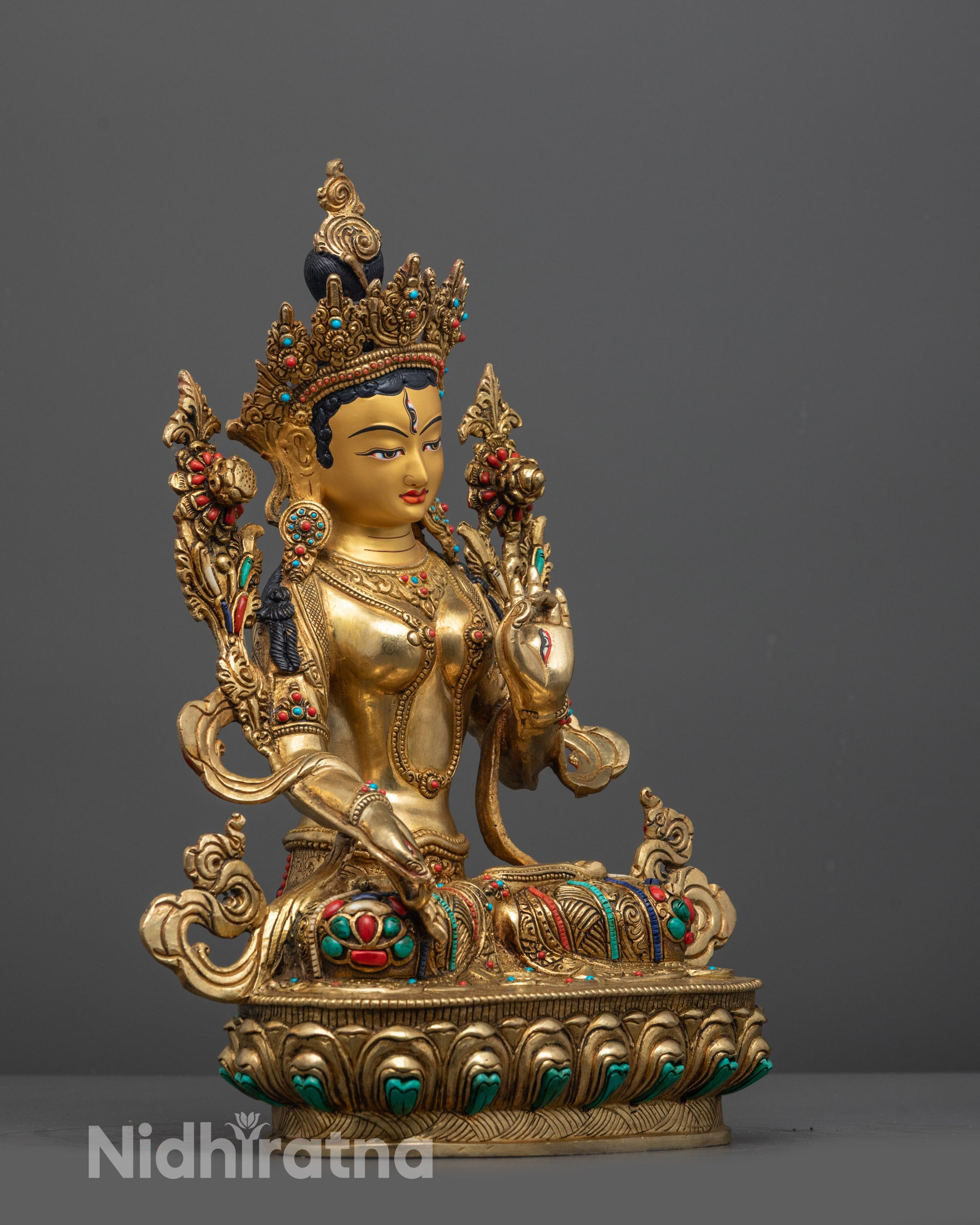 Side view of White Tara statue with floating robe and semi-precious stones