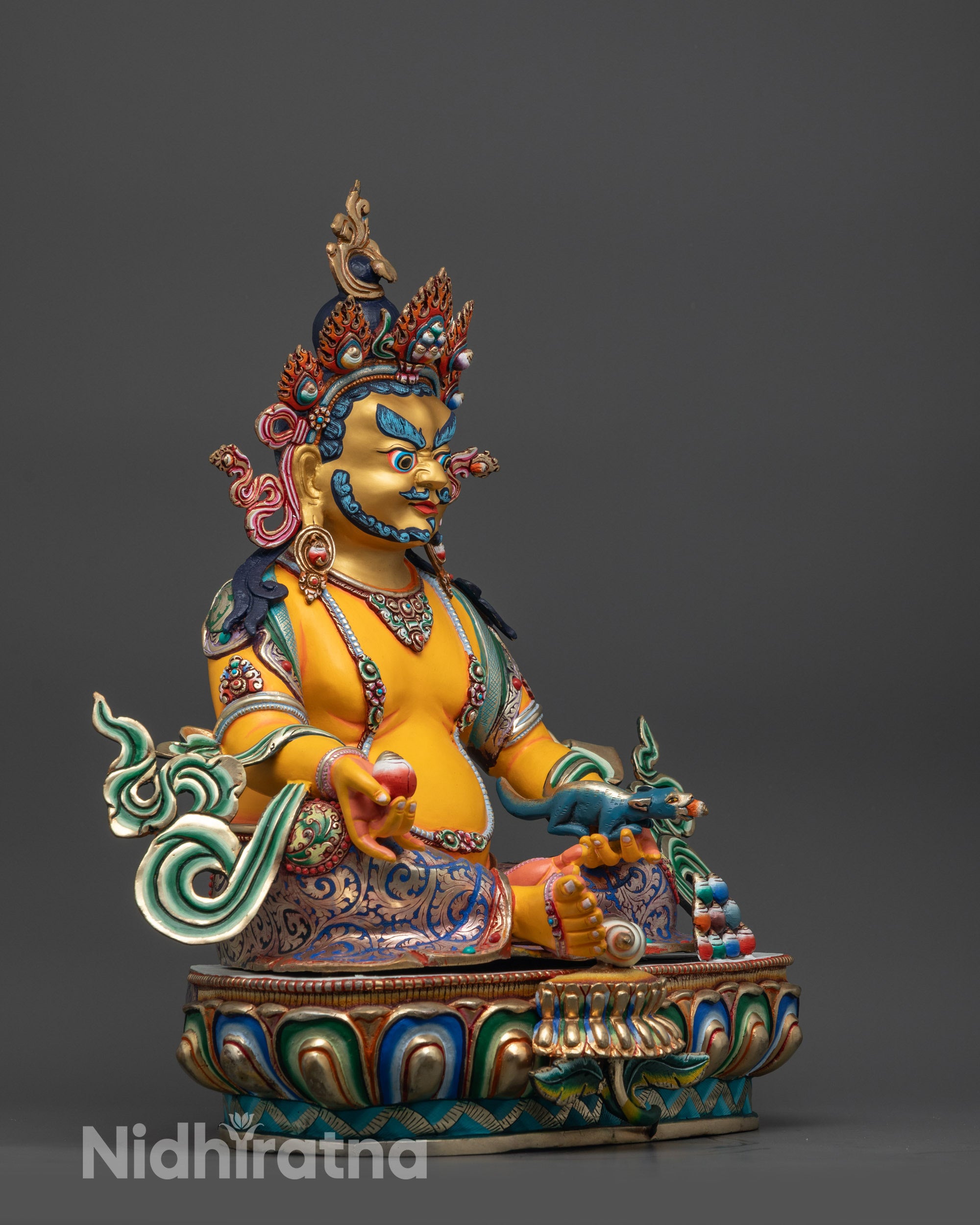Side view of Yellow Dzambhala statue holding citrion fruit and jewel-spitting mongoose