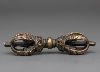 Side view of bronze vajra with detailed carvings for Vajrayana practice