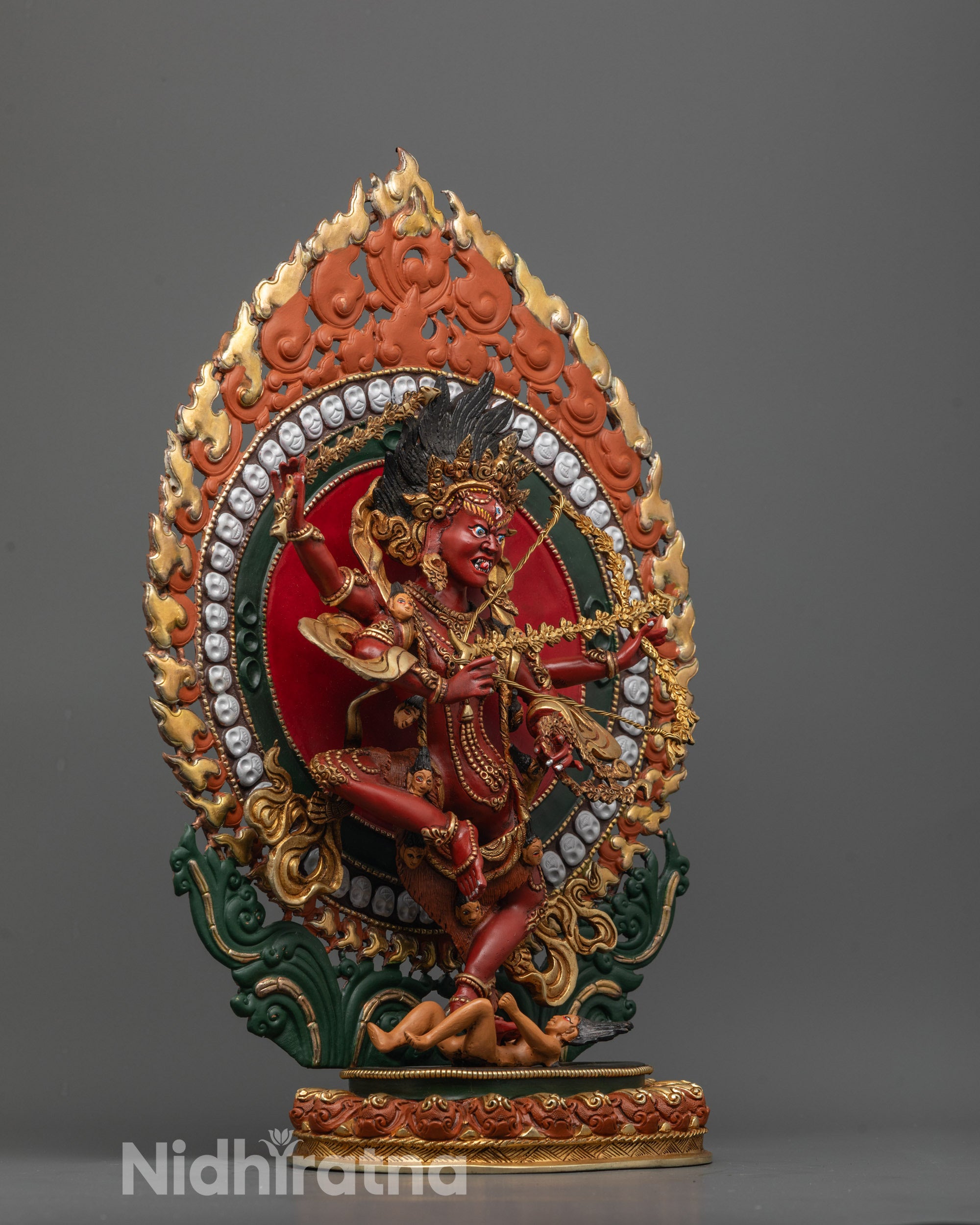 Side view of dancing Kurukulla with gold-plated skull garland and halo glow