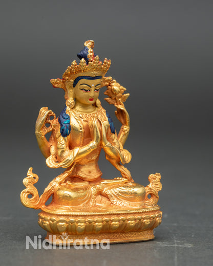 Side view of four-armed Chenrezig statue holding crystal mala and lotus flower