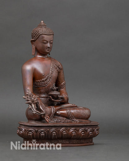 Side view of handcrafted Nepalese Medicine Buddha statue showing intricate lost-wax casting details and chemically oxidized finish