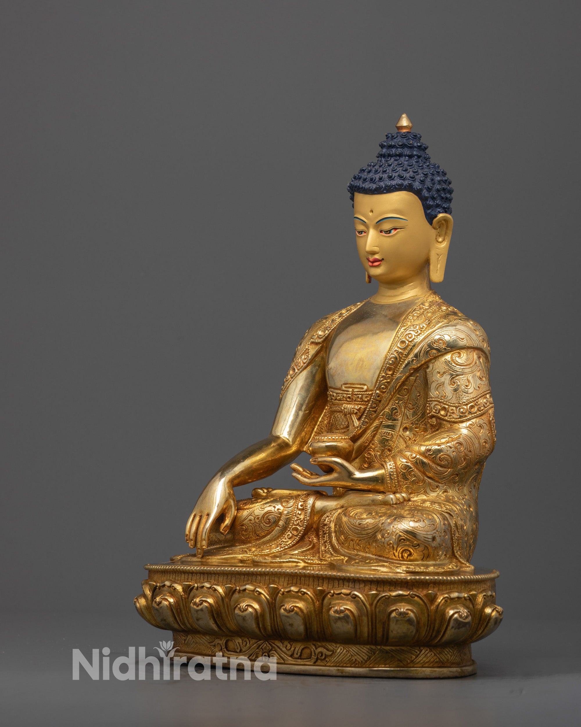 Side view of handcrafted Shakyamuni Buddha showing robe patterns and lotus seat