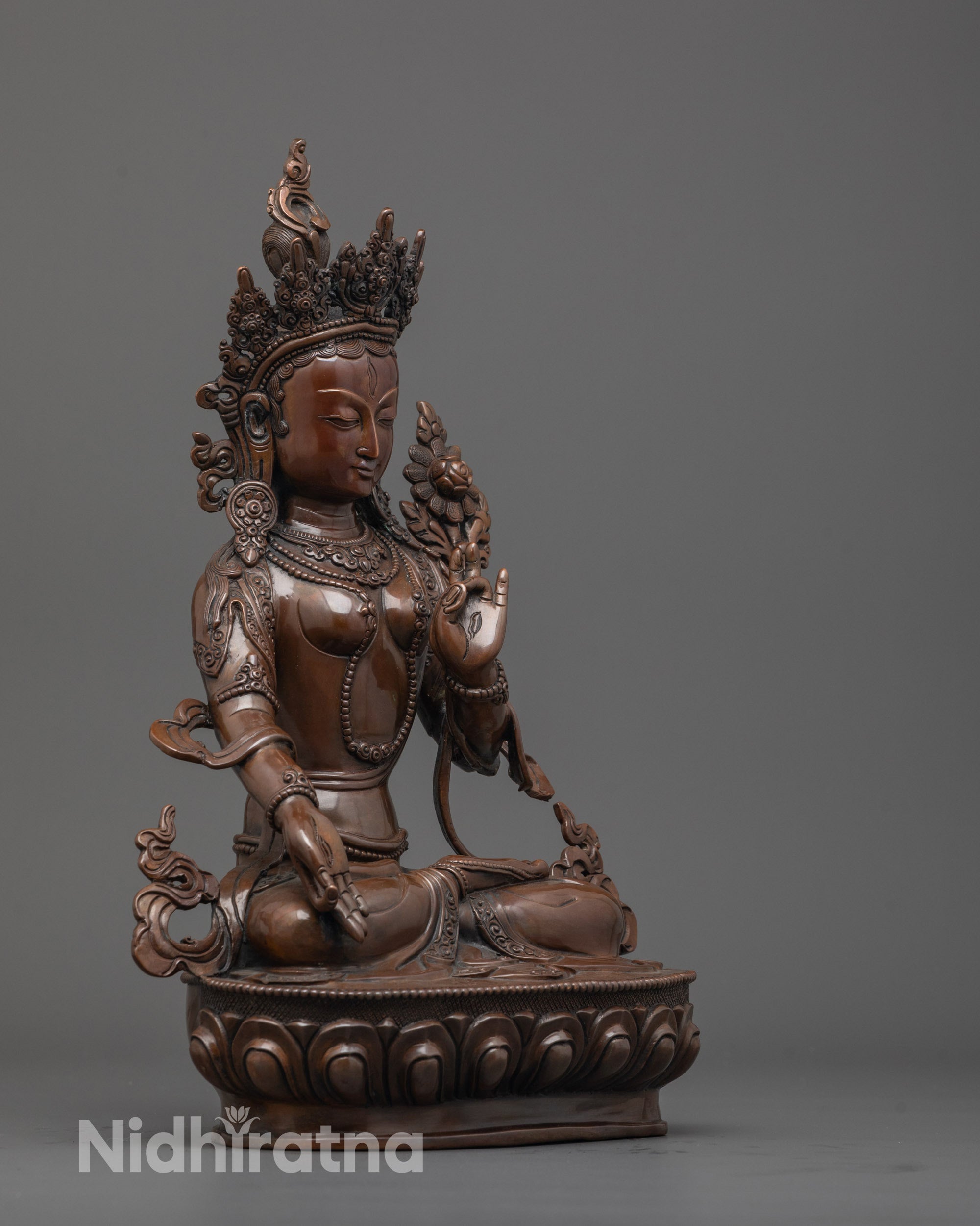 Side view of handcrafted White Tara statue holding utpala flower in blessing mudra