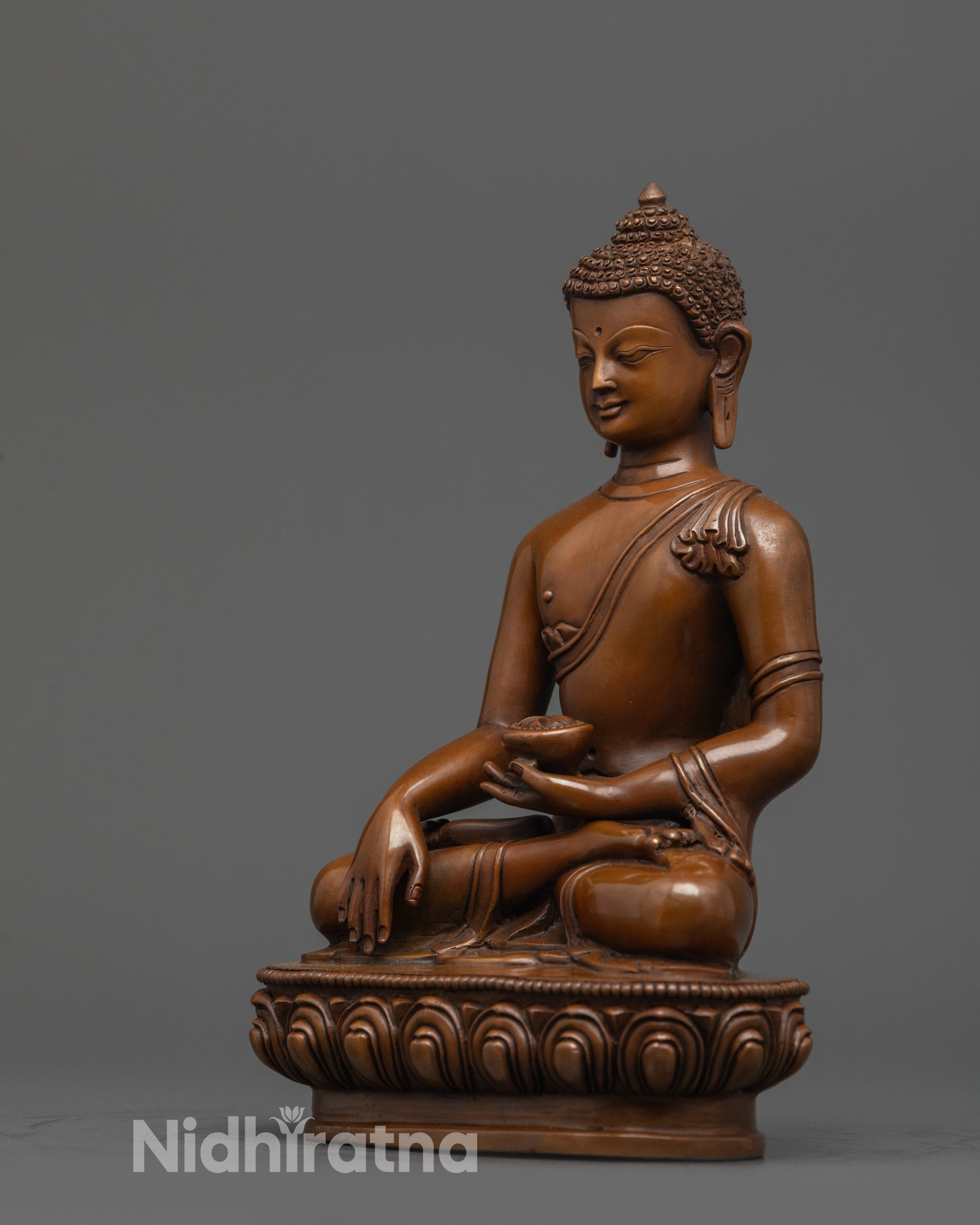 Side view of oxidized copper Shakyamuni Buddha with monk robe and patra bowl