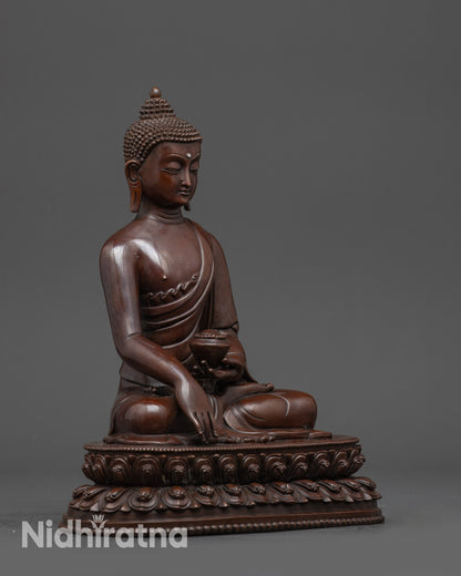Side view of oxidized copper Shakyamuni Buddha draped in monk’s robe