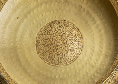 Side view of traditional copper Tibetan Urli offering bowl with patterned carvings