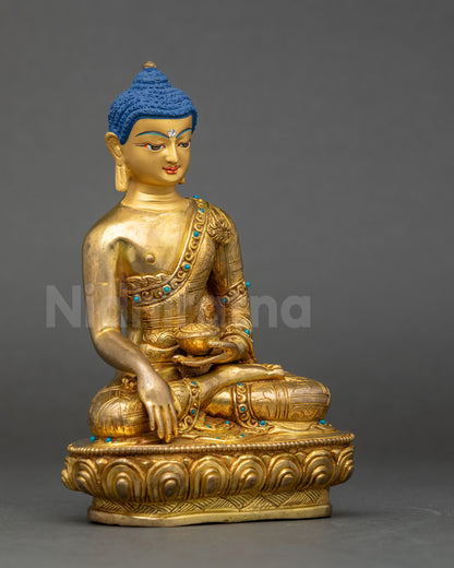 Side view of traditional lost wax Nepalese Buddha statue with intricate robe carvings