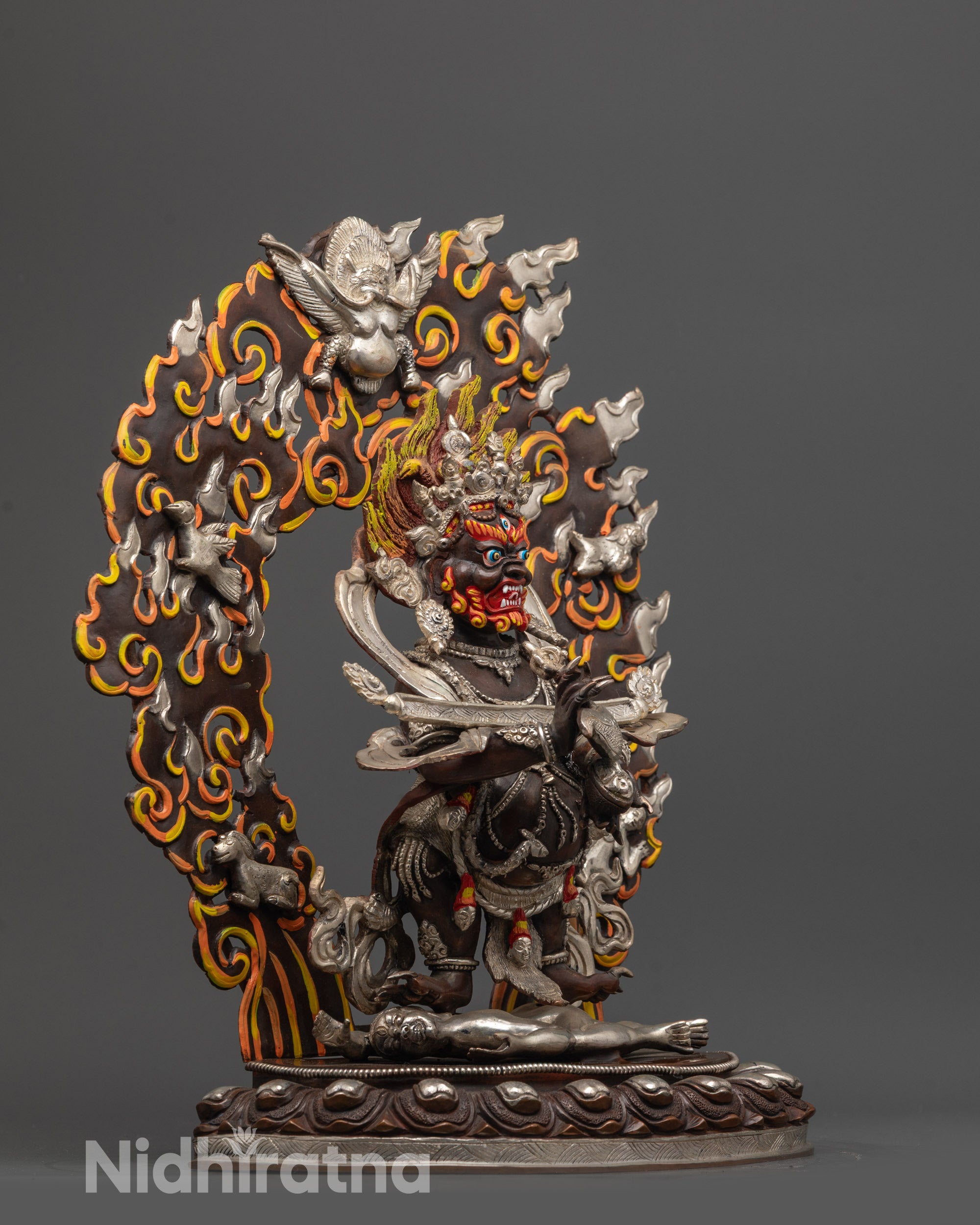 Side view of wrathful Shakya Mahakala statue with serpent garland and swirling robe
