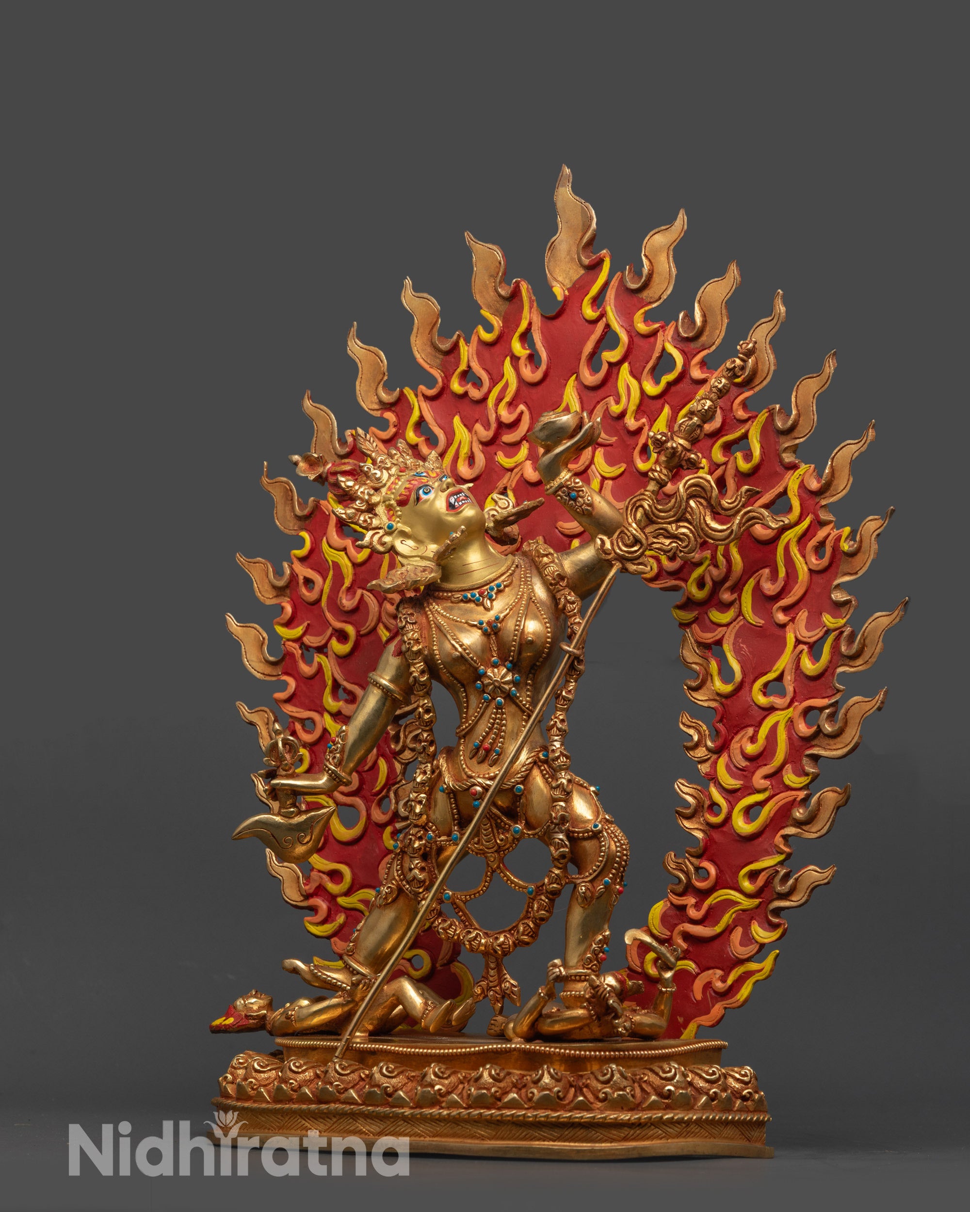 Side view of wrathful Vajrayogini Statue on lotus seat with subdued human figures