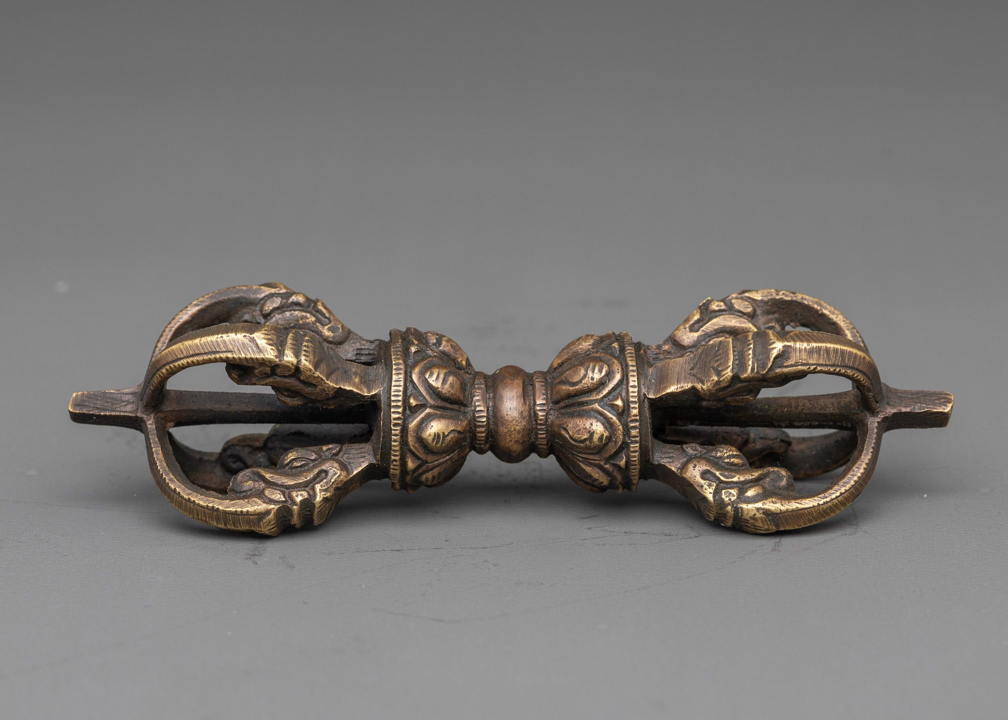 Side view intricate bronze vajra with detailed carvings for tantric ceremonies