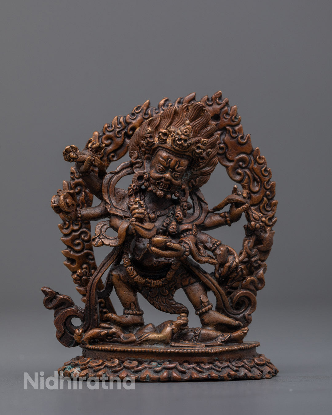 Six-Armed Oxidized Mahakala statue in copper with fierce expression and radiant halo