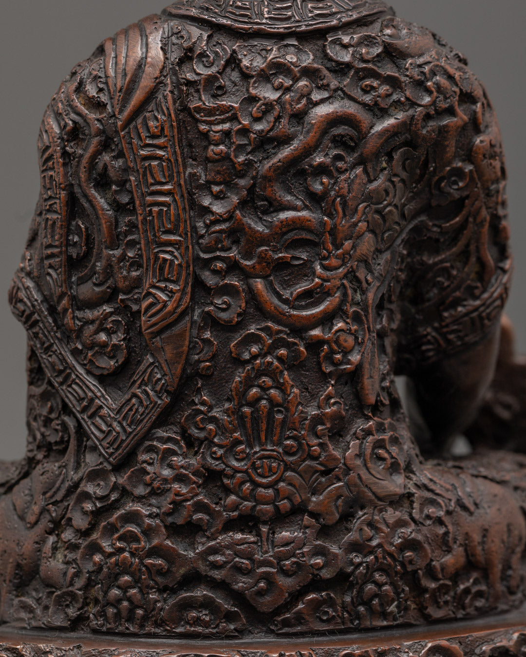 Skilled Nepalese artisan hand-carving the Medicine Buddha statue using traditional lost wax method.