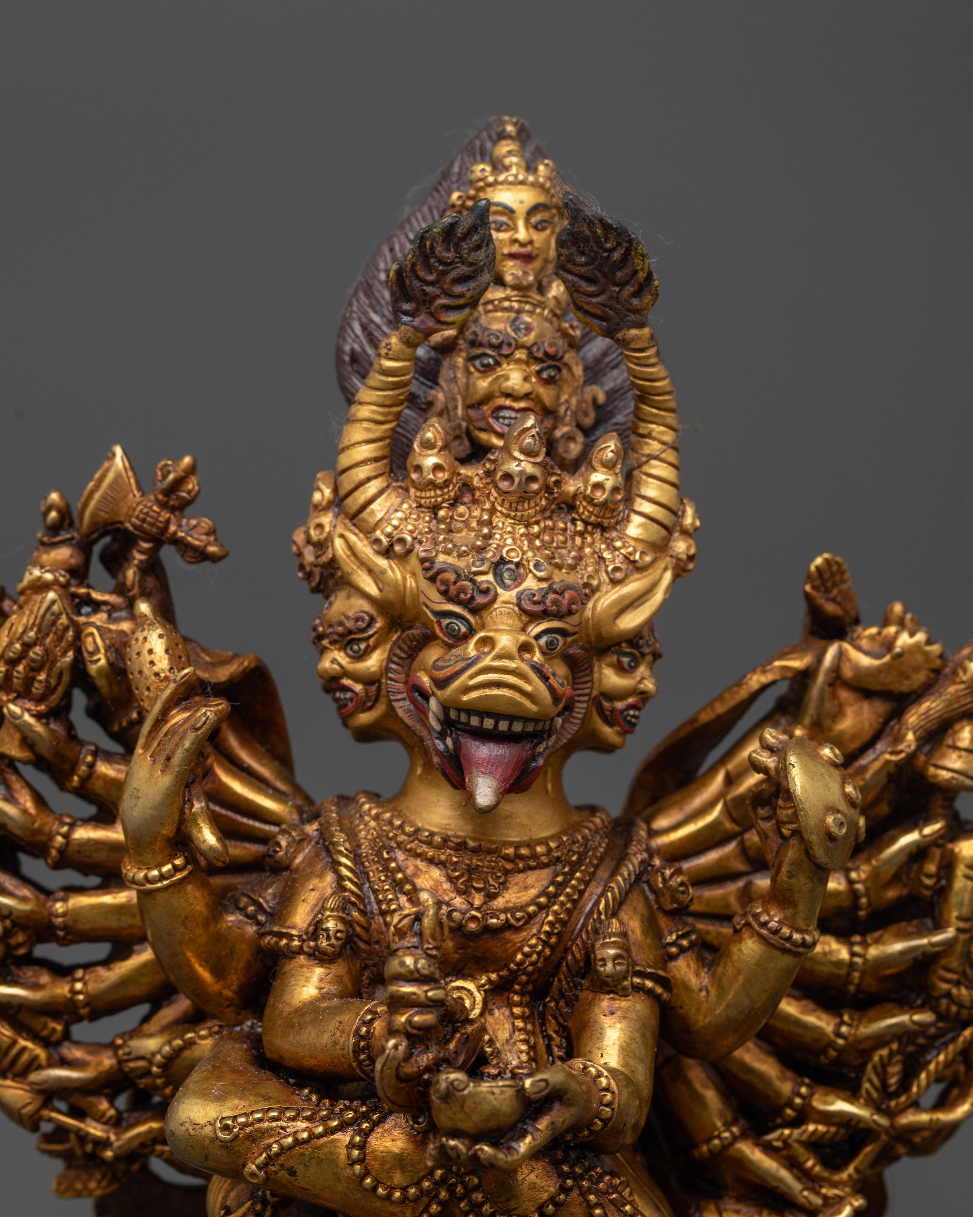 Close up Yamantaka Statue showing nine faces and sacred objects in detailed carving
