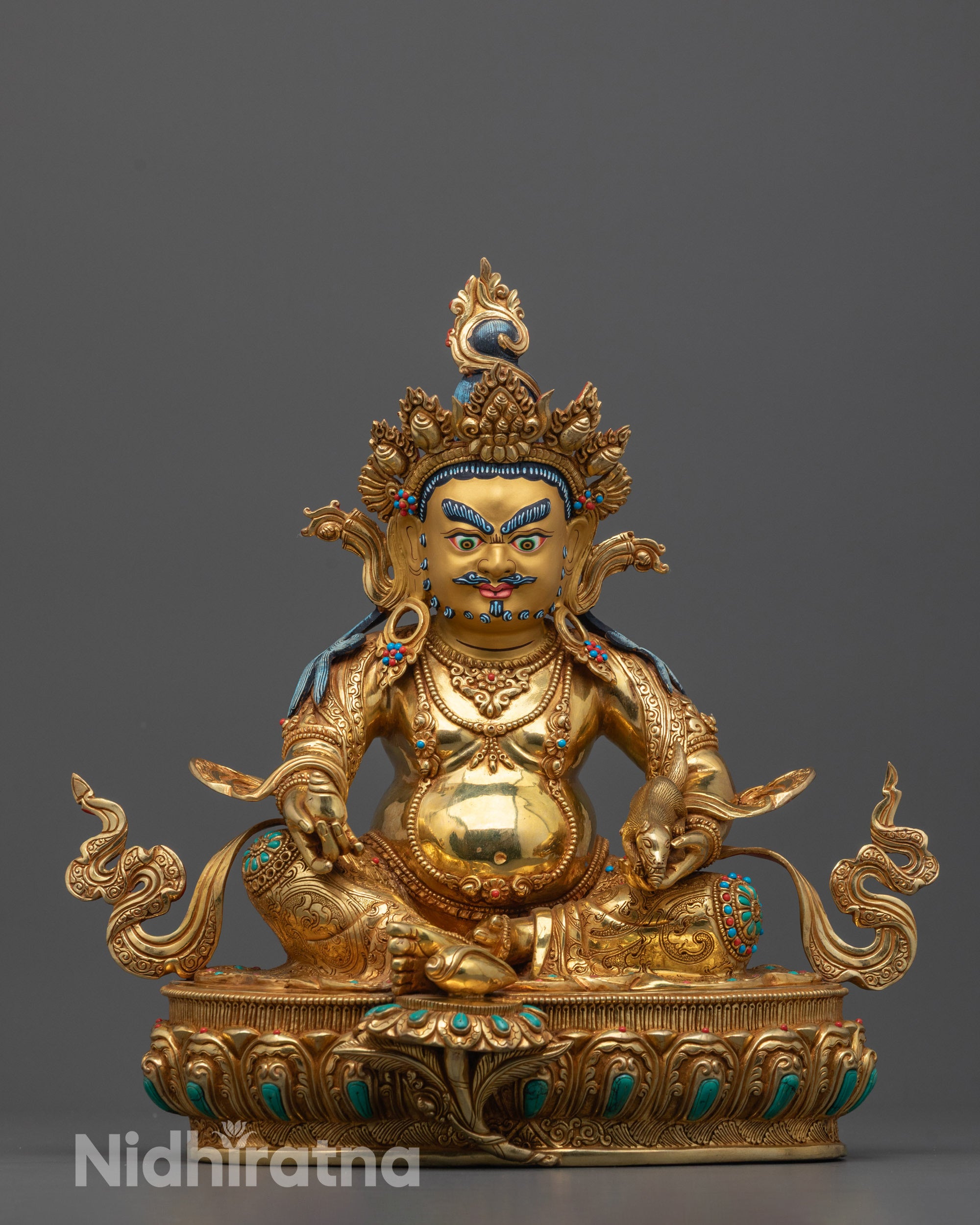 Front view of Dzambhala statue with gold-gilded face and jewel-adorned robe