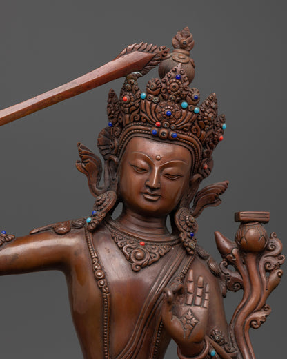 The Manjushri statue featuring a flaming sword in the right hand and a scripture in the left, representing the cutting of ignorance and cultivation of wisdom.