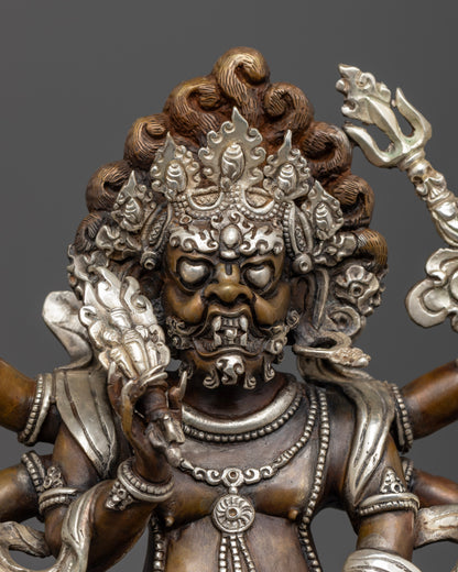 The White Mahakala statue’s detailed silver-coated face and ornate features, showcasing expert Nepalese craftsmanship and colorful accents.