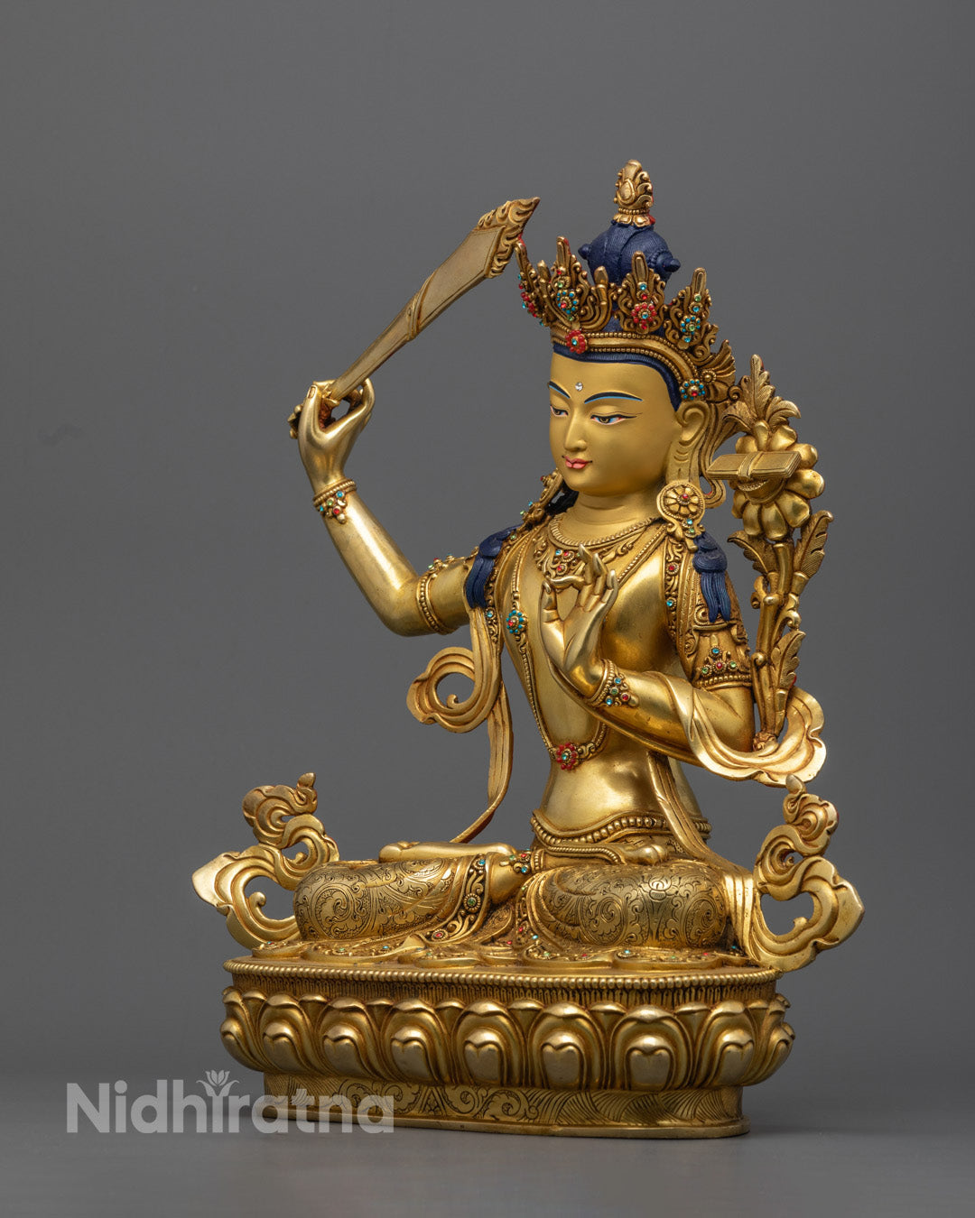 The gold Manjushree statue, highlighting the wisdom sword and intricate details, represents the power of cutting through ignorance.