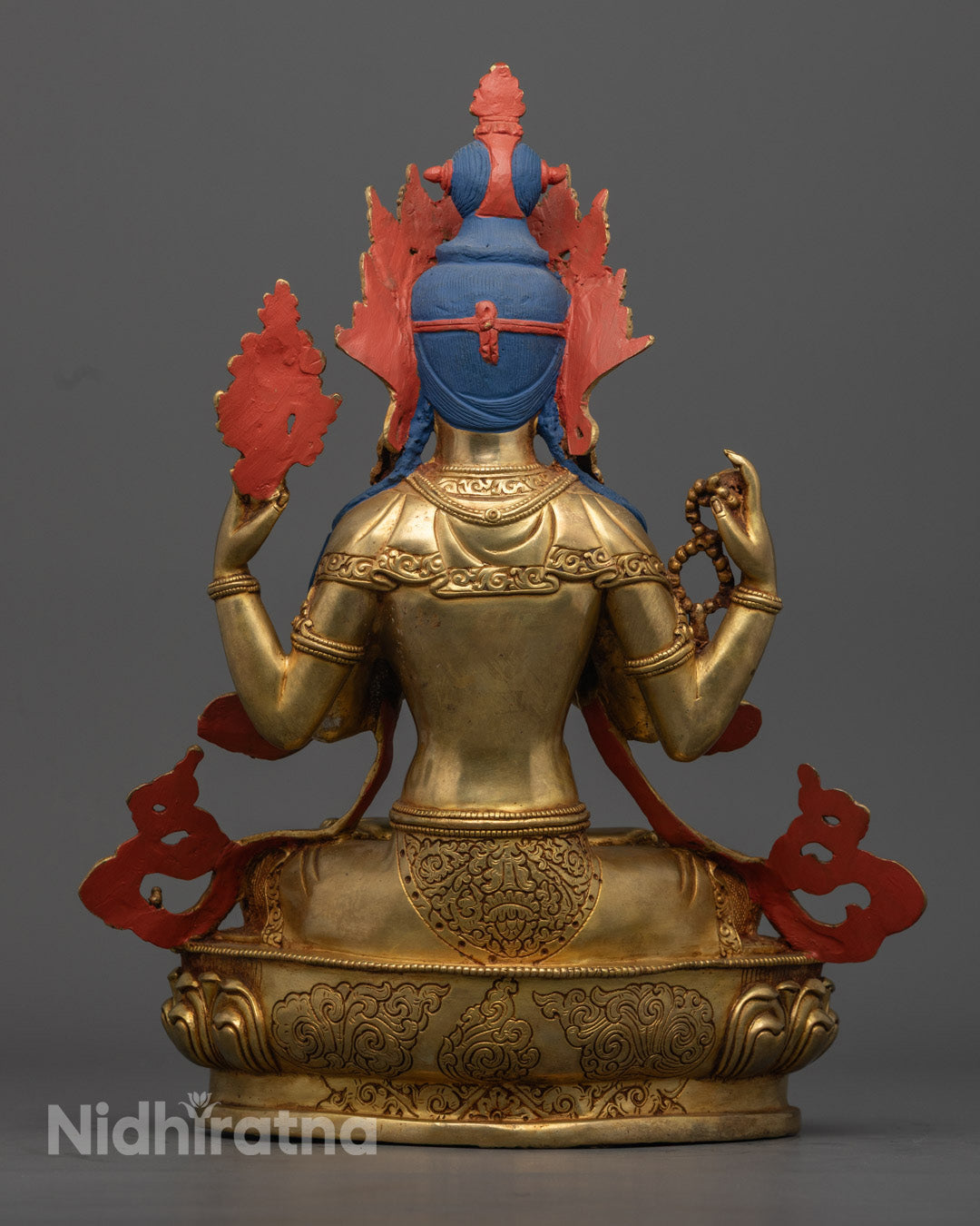 The upper right hand of the Chenrezig statue holding an utpala flower, with a finely sculpted robe and intricately detailed crown showcasing exceptional craftsmanship.
