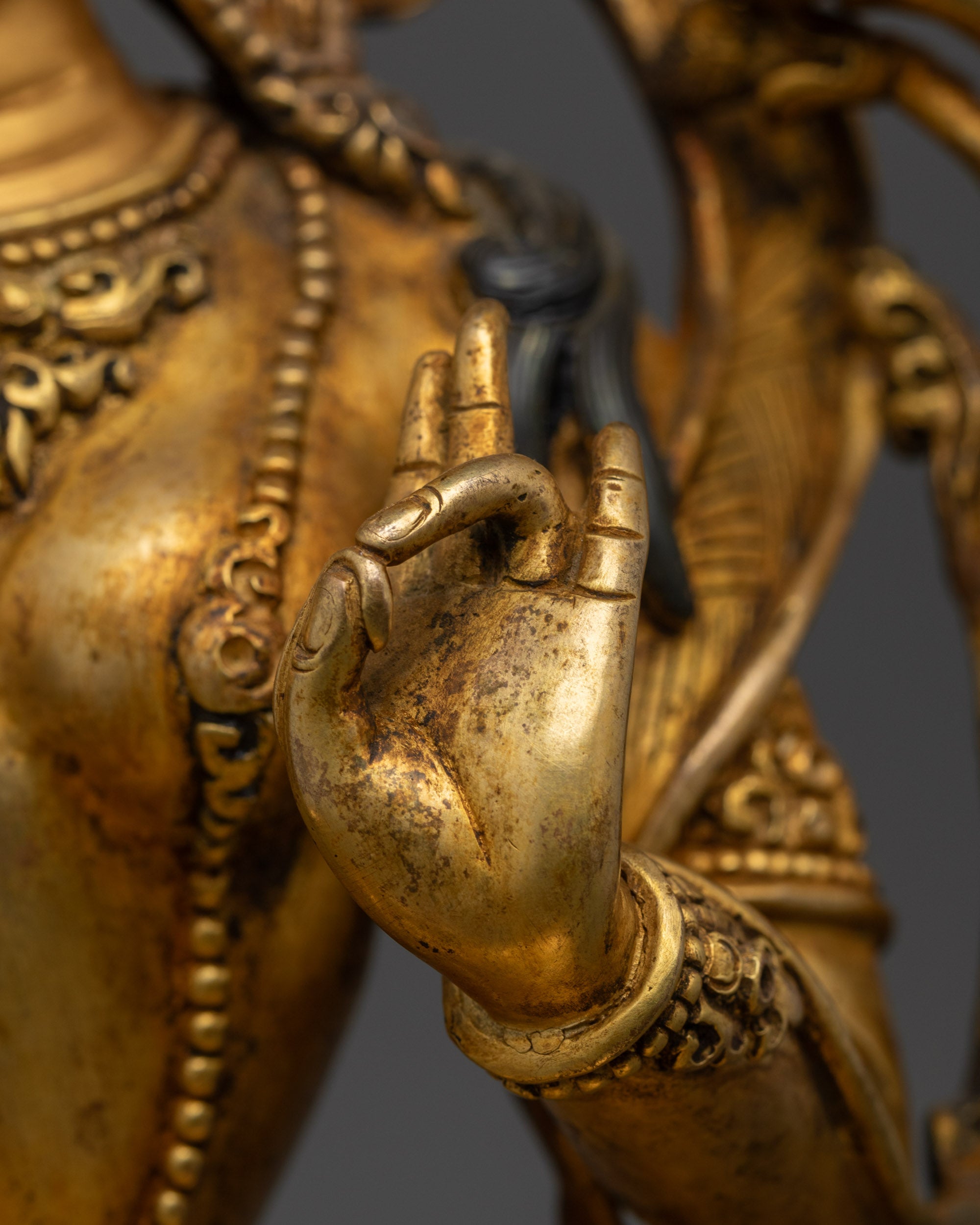 Three-quarter view Green Tara offering fearlessness with blossoming utpala and jewelry