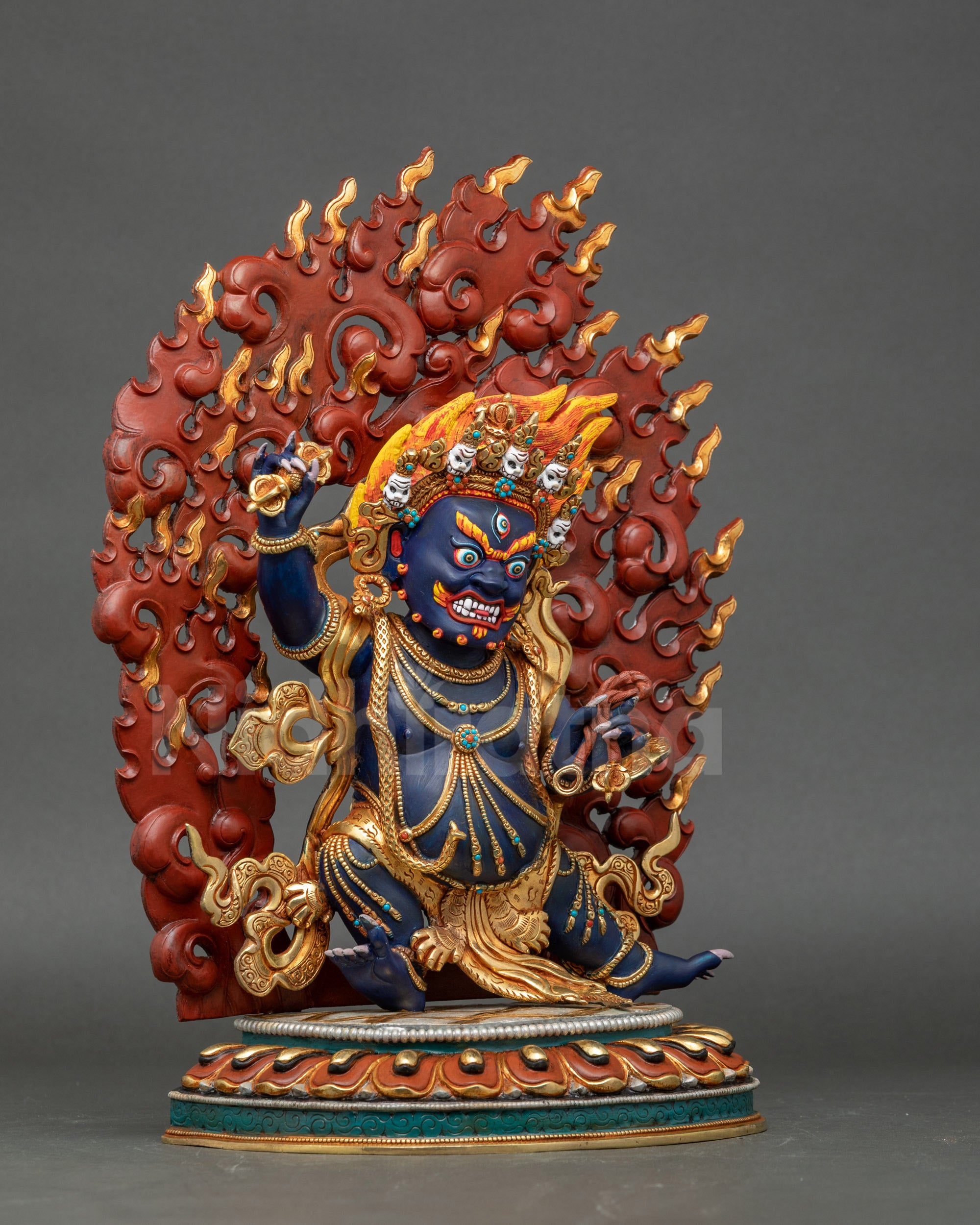 Tibetan Buddhist Chagna Dorje Vajrapani statue with gold robe and fierce protector gaze.