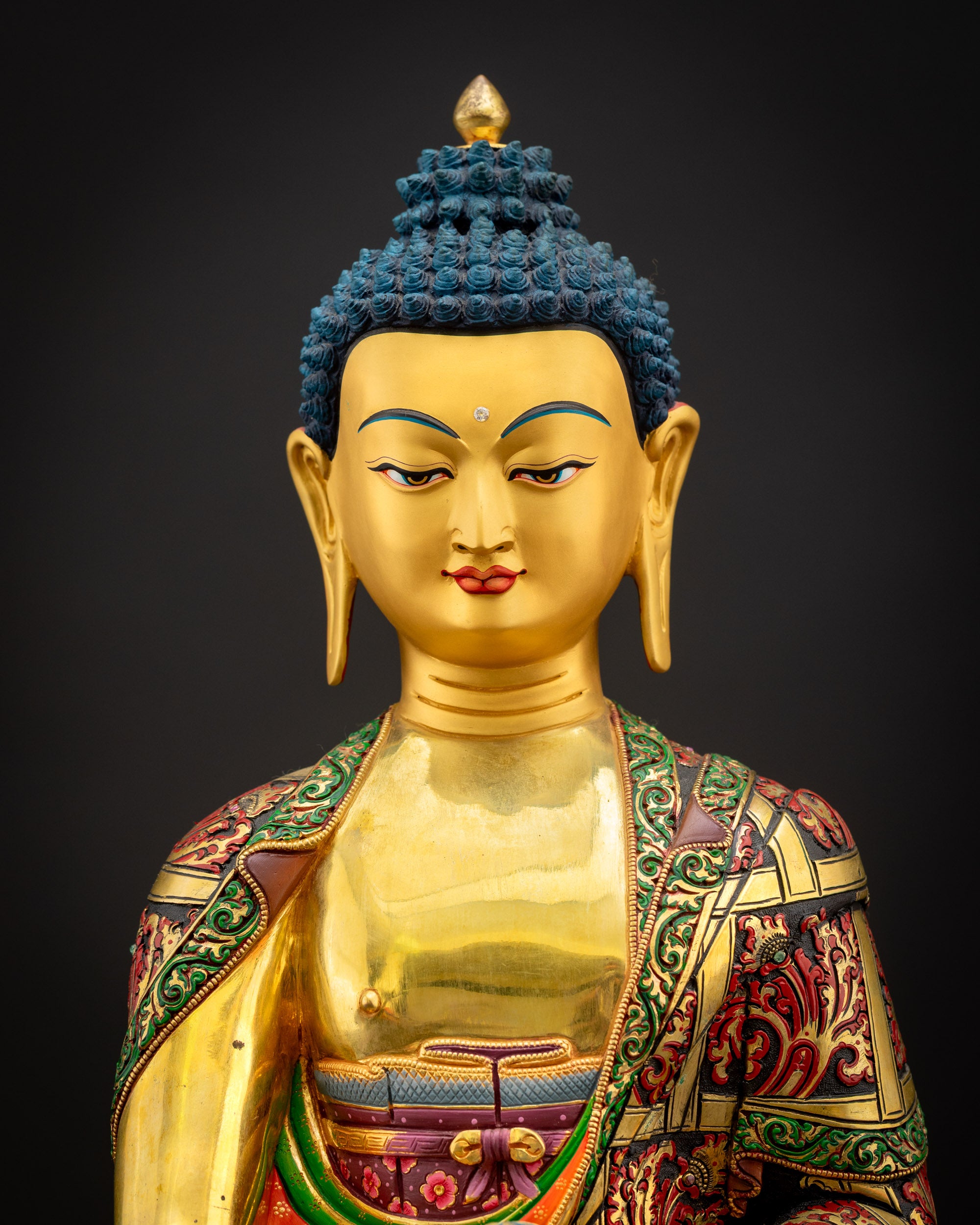 Close-up of Shakyamuni Buddha Statue highlighting serene facial expression and polished gold-fire gilding