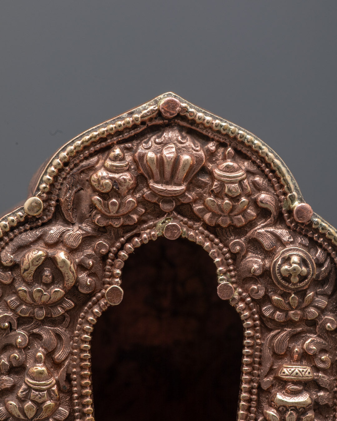 Top-down close-up of hollow section inside gold Tibetan Ghau Box for sacred relics