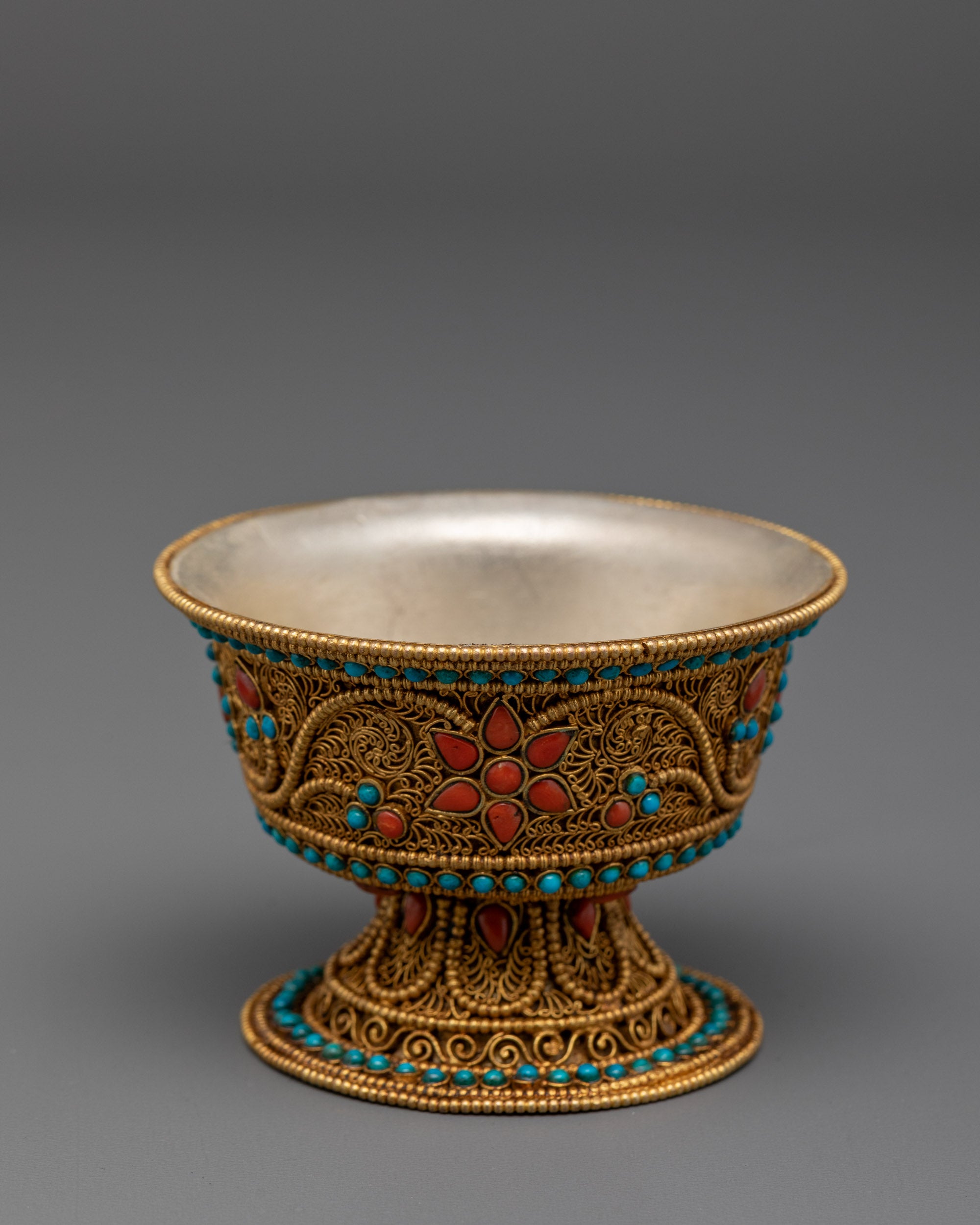 Top view of handcrafted water offering bowl with engraved silver and gemstone details