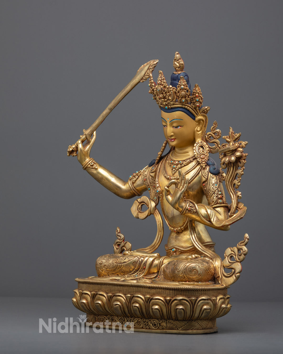 Traditional Manjushri Buddhist statue standing on lotus base, featuring vivid acrylic colors and gold accents.