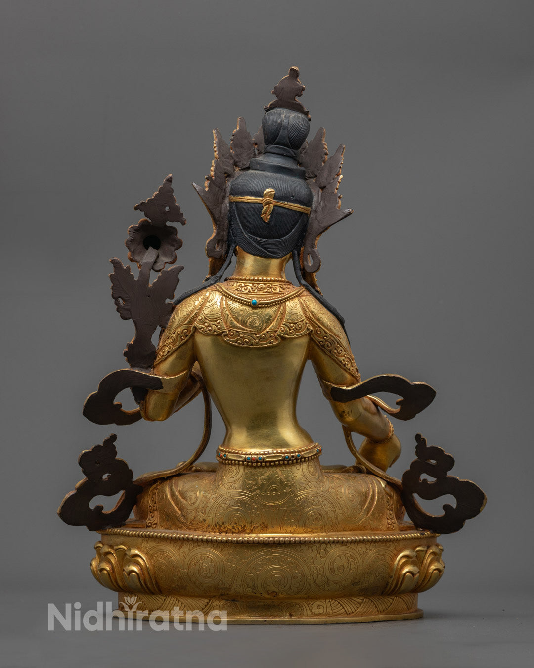 Traditional Nepalese White Tara statue on display, showcasing intricate craftsmanship with fire-gilded copper and vivid acrylic colors.