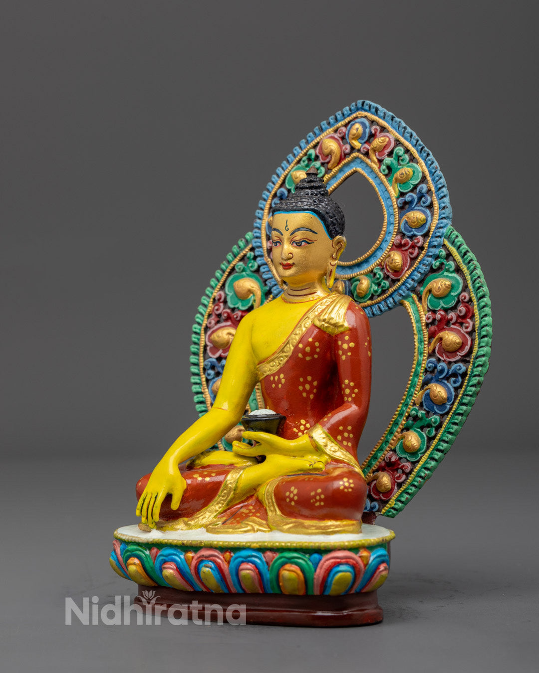 Traditional Nepalese electroplated Shakyamuni Buddha statue painted with vibrant yellow acrylic colors, seated on a gold-plated throne.