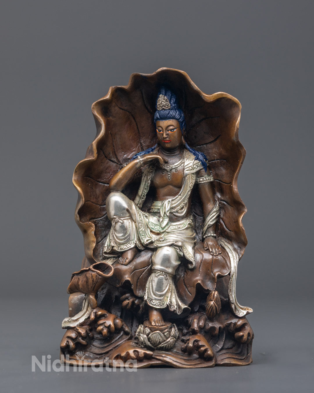 Traditional Nepali artisan painting acrylic colors on a Lokiteshvara statue using the lost wax method.