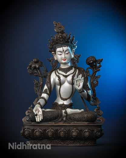Hand-carved Tibetan White Tara Statue seated on an oxidized lotus base, adorned with semi-precious stones and white-silver acrylic finish.