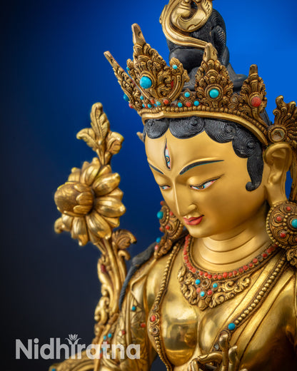 Upper detailed close up face White Tara statue seven-eyed goddess gold-gilded face

