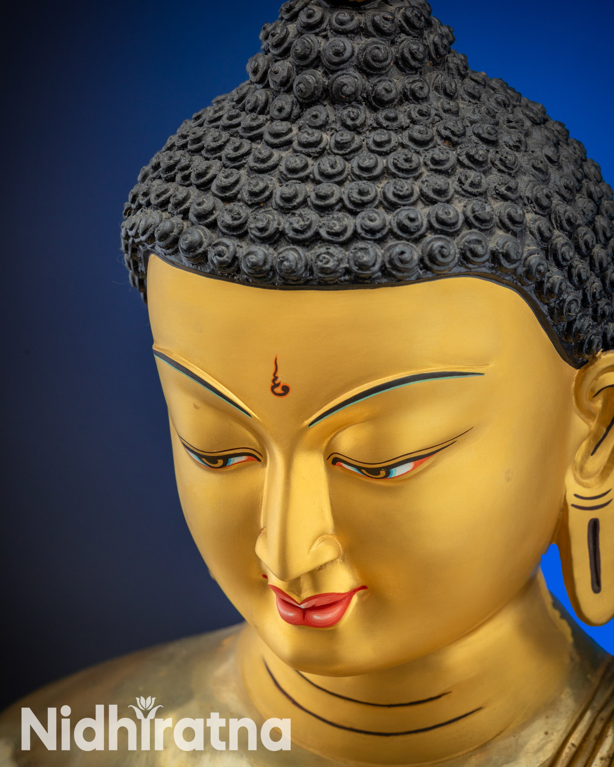 Upper face close up of gold gilded Shakyamuni Buddha statue from Nepal for altar