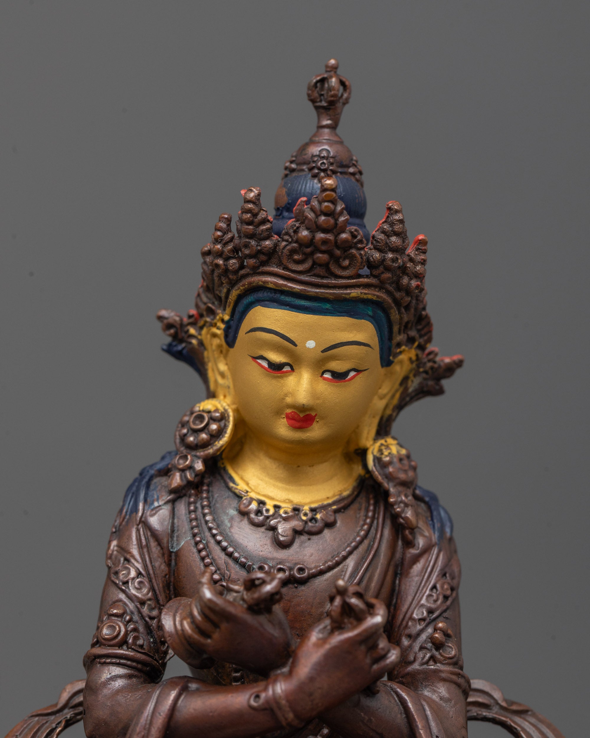 close up of vajradhara statue showing jeweled crown and tranquil expression