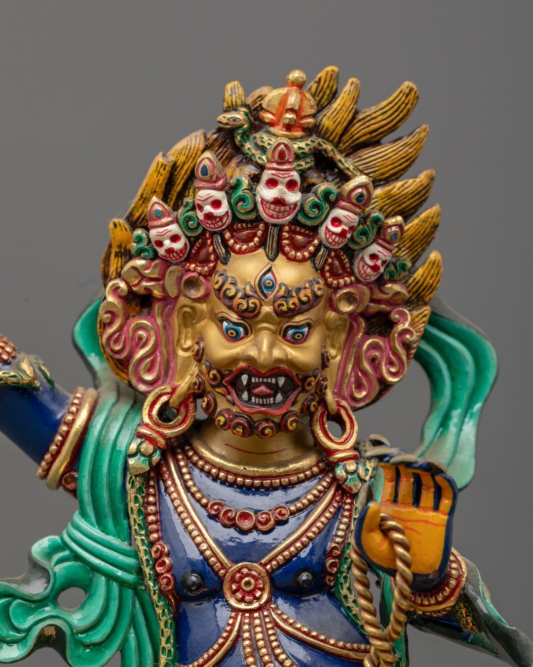 Vajrapani’s gold-gilded face, five-jeweled crown, third eye, and fierce expression, showcasing intricate lost wax craftsmanship and vibrant paintwork