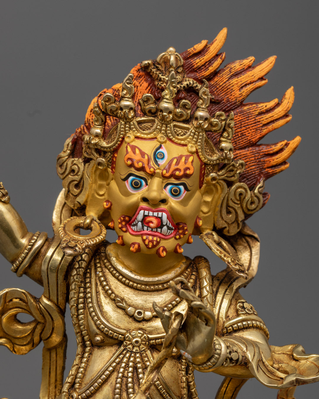 Vajrapani sculpture’s pure gold-gilded face and body with vibrant acrylic colors on floating robe and jewelry.